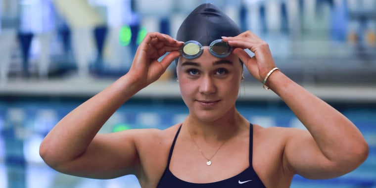 Ali Truwit lifts up her swimming goggles by the pool