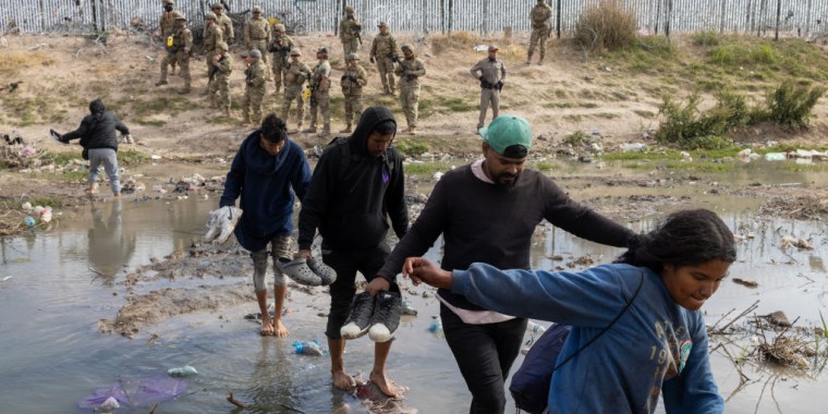 Miembros de la Guardia Nacional de Texas dispersan a un grupo de migrantes en la frontera de Estados Unidos con México, en río Grande, el 20 de abril de 2024.
